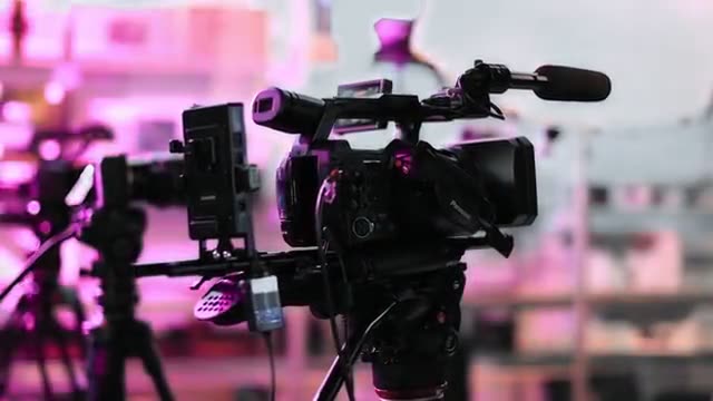 Cinemacamera op een filmset met magenta licht